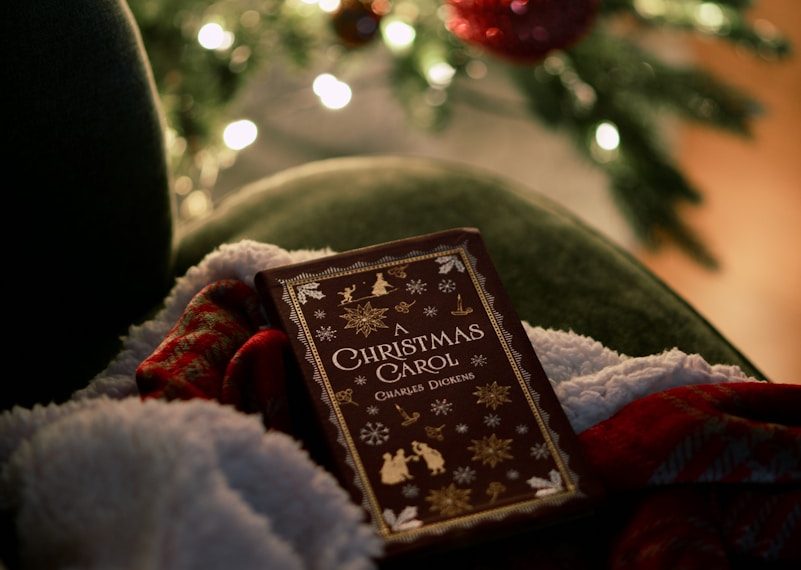 a book sitting on a blanket in front of a christmas tree